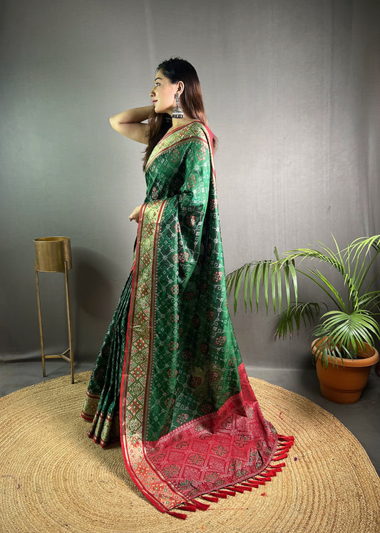 dark Green Soft Rangeen Patola Silk Saree with All-Over Meenakari Weaving, Rich Pallu, and Tassels – Includes Unstitched Blouse Piece.