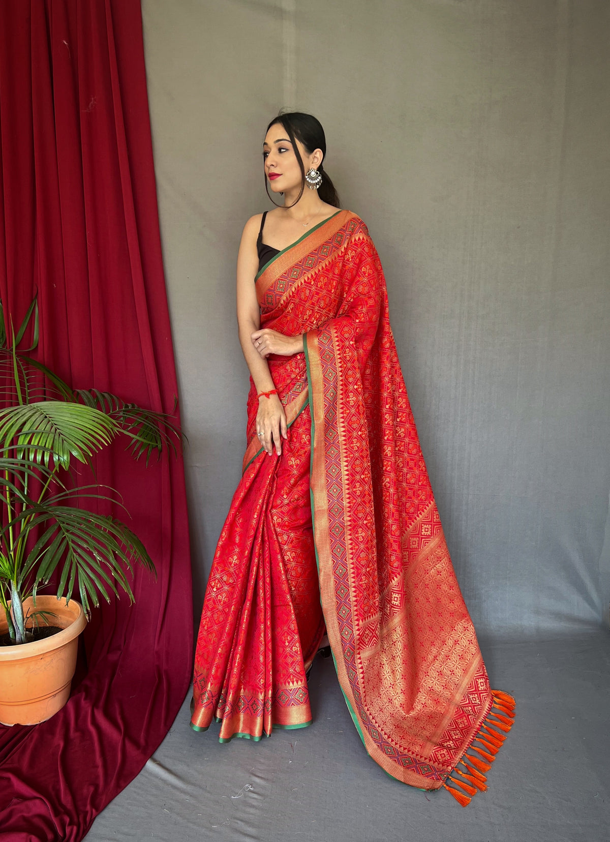 Red Color Pure Patola Silk Saree with Patola Fusion Design, Contrast Meenakari Work, Rich Pallu with Tassels – Includes Unstitched Blouse Piece.